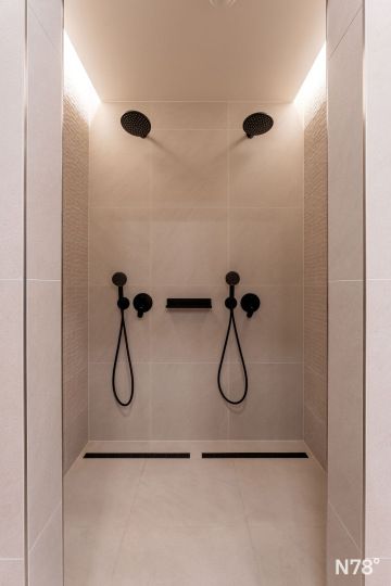 Interiér centra osobního rozvoje – sprchy a nepřímé osvětlení.